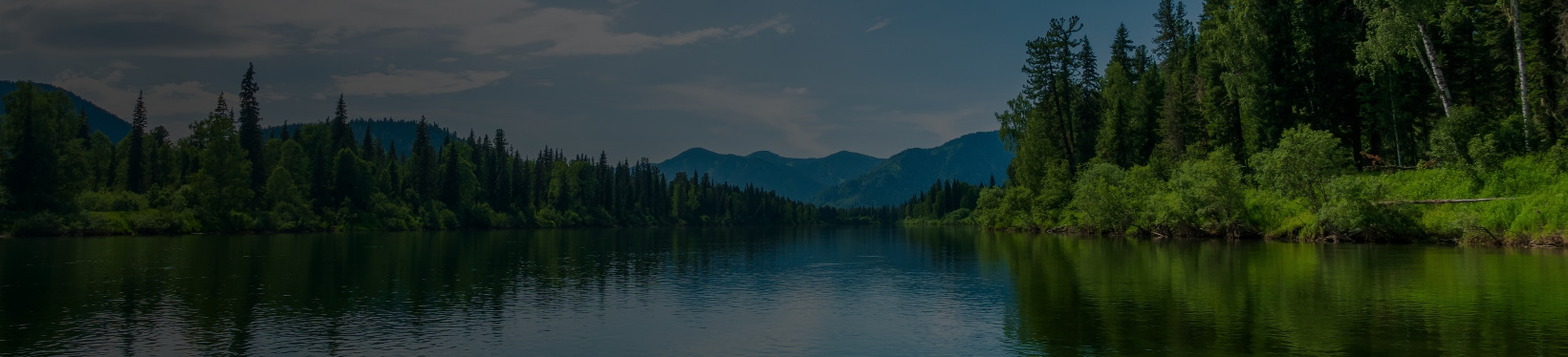 Big lake middle mountains with trees in the background