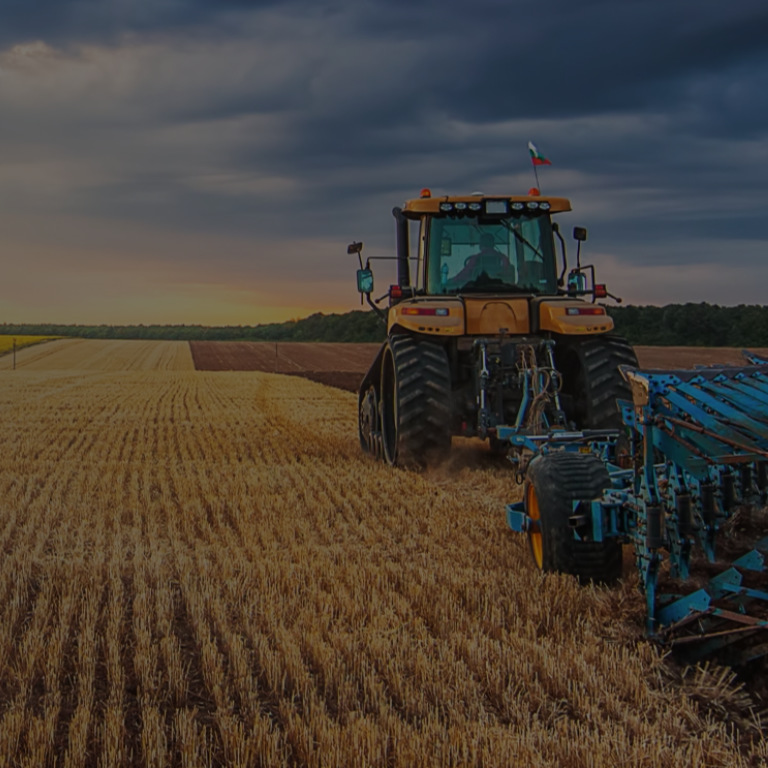 Tractor on farm during sunset