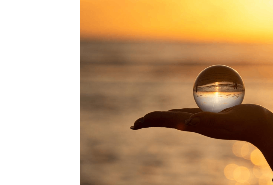 Hand holding globe near ocean